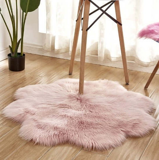 Soft pink artificial woolen carpet rug under a chair, adding warmth and style to a modern interior.