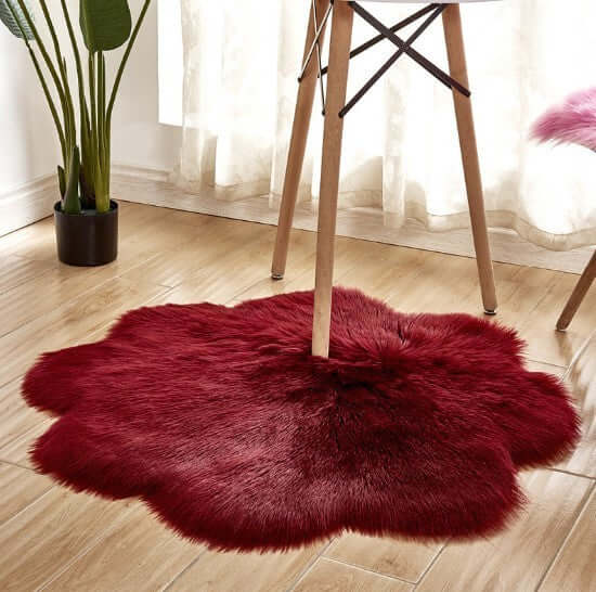 Red plush artificial woolen carpet rug under a table, adding warmth and style to home decor.