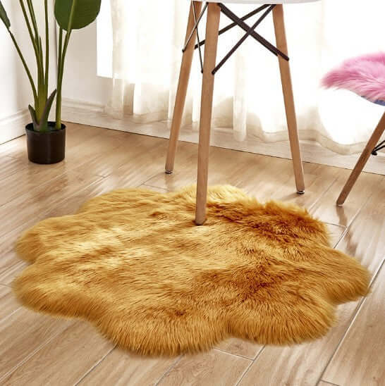 Plush artificial woolen carpet rug in a golden color, placed under a chair in a stylish living space.